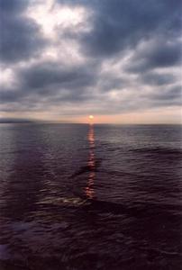 Red reflection line on dark ocean and sky
