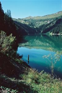 Turquoise alpine lake reflecting mountains